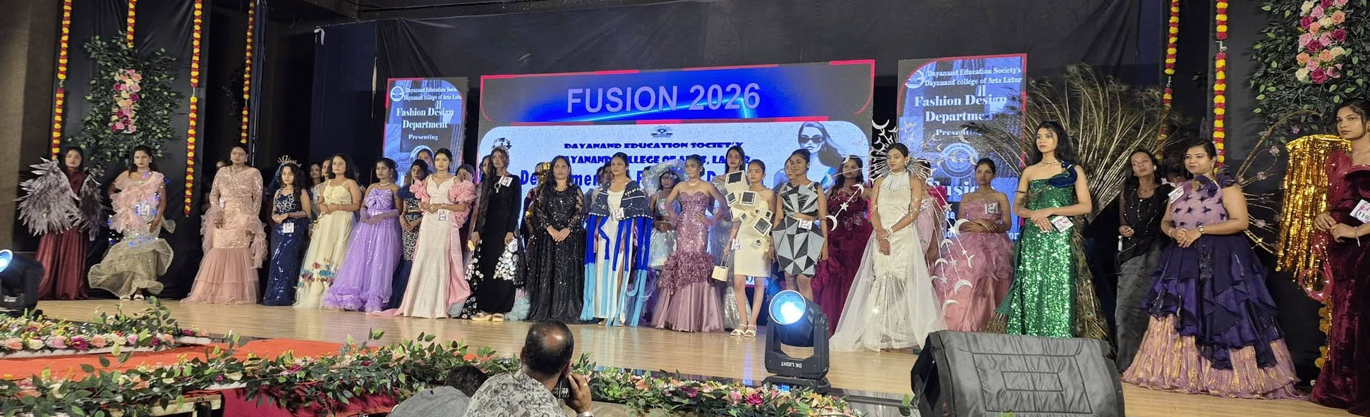 State-level fashion show event at Dayanand Kala Mahavidyalaya Latur with students performing confident ramp walk under bright stage lights.