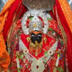 माँ विंध्यवासिनी की सुंदर प्रतिमा, लाल चुनरी और स्वर्ण आभूषणों से सजी हुई, नवरात्रि पूजा का दृश्य