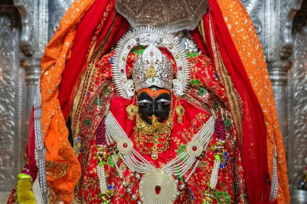 माँ विंध्यवासिनी की सुंदर प्रतिमा, लाल चुनरी और स्वर्ण आभूषणों से सजी हुई, नवरात्रि पूजा का दृश्य