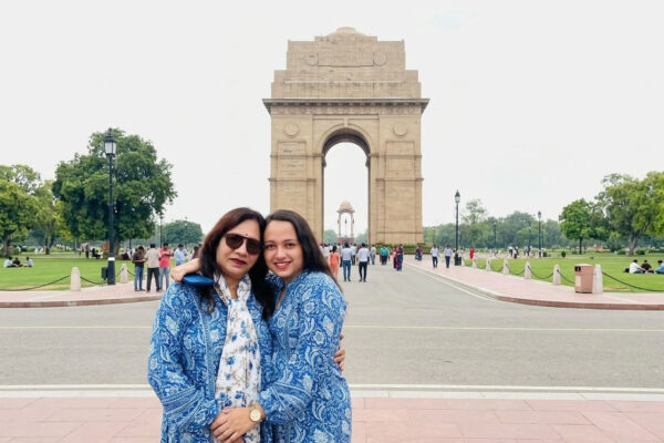 आँगन में खड़ी बेटी को प्रेम और आशीर्वाद देते माता-पिता का भावनात्मक दृश्य।