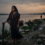 विरह में डूबी एक स्त्री, दूर जाती परछाईं को निहारती हुई, आँखों में प्रेम और प्रतीक्षा का गहरा भाव।